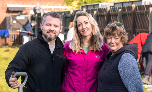 3 people standing in a garden